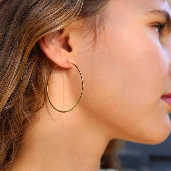 Model wearing Hand made in London Brooke Gregson 18k gold hammered hoop earrings