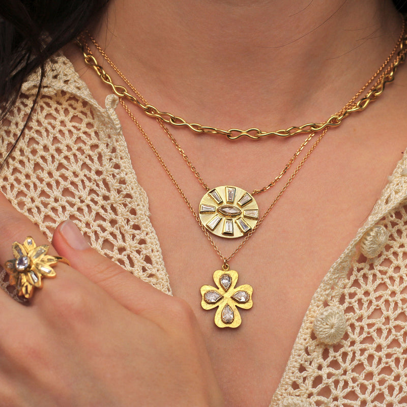 Model wearing One of a kind, hand engraved 18k gold White Diamond necklace in a floral cross. Fine jewelry hand made in London from Los Angeles designer Brooke Gregson. 