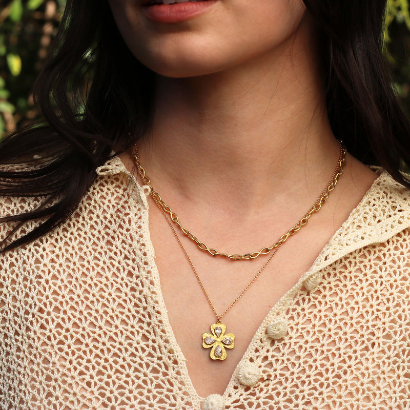 Model wearing One of a kind, hand engraved 18k gold White Diamond necklace in a floral cross. Fine jewelry hand made in London from Los Angeles designer Brooke Gregson. 