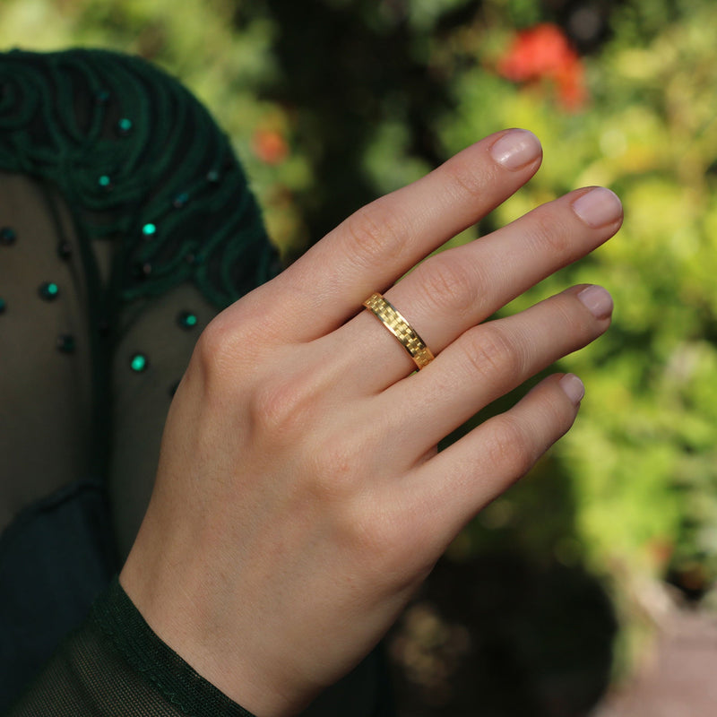 Model wearing 18k gold band with engraved basket weave pattern. Fine jewellery hand made in London  from Los Angeles designer Brooke Gregson