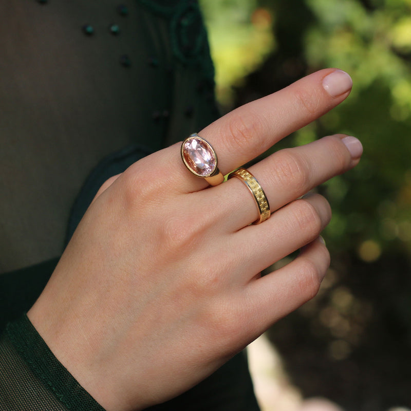 Model wearing 18k gold Kunzite ring featuring an engraved basket weave pattern reminiscent of a picnic in springtime. Fine jewelry hand made in London from Los Angeles designer Brooke Gregson.